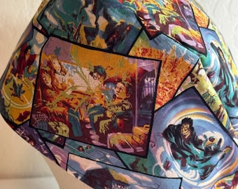 May include: A blue, yellow, and green patterned fabric scrub hat with a black tie. The fabric features a repeated pattern of images from the Harry Potter series.