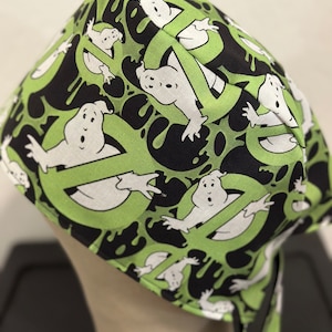 May include: Green and black fabric head wrap with a repeating pattern of white ghosts and green slime. The ghosts are wearing a no ghost sign.
