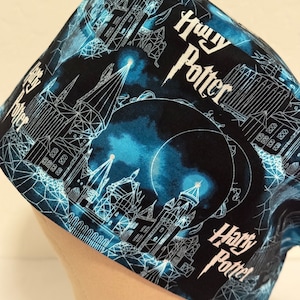 May include: A black scrub hat with a blue and white design featuring the Hogwarts castle and the words "Harry Potter".