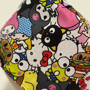 May include: A colorful fabric with a variety of cartoon characters, including Hello Kitty, My Melody, and Kuromi. The fabric is white with black outlines and features a variety of colors, including pink, yellow, blue, and green.