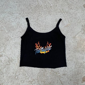 May include: Black spaghetti strap tank top with a graphic print of flames and the text "Ted Nugent".