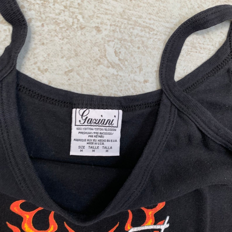May include: Black tank top with a flame graphic and the text "Gaziani" on the tag. The tag says 100% cotton, pre-shrunk, made in the USA, and size M.