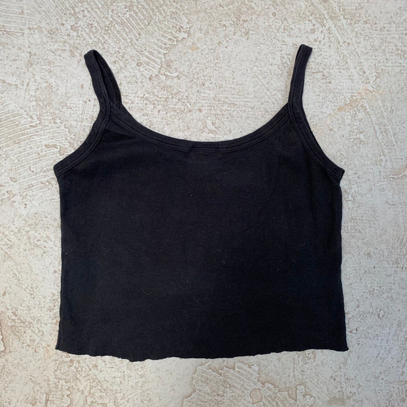 May include: A black sleeveless cropped tank top with a scoop neck.