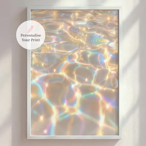 Pode incluir: Uma impressão emoldurada com uma imagem abstrata de água com reflexos de luz. A superfície da água brilha com tons dourados, amarelos e arco-íris. O texto "Personalise Your Print" está em um círculo branco no canto superior esquerdo.