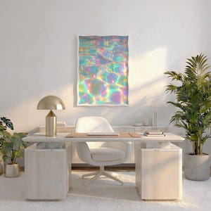 Pode incluir: Um espa&ccedil;o de escrit&oacute;rio moderno com uma secret&aacute;ria, cadeira e tapete brancos. Uma obra de arte emoldurada com um design de &aacute;gua iridescente e colorido est&aacute; pendurada na parede. Uma l&acirc;mpada de secret&aacute;ria dourada e plantas em vasos completam a decora&ccedil;&atilde;o.