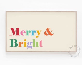 以下が含まれることがあります： 「Merry & Bright」というテキストがカラフルな文字で書かれた額装されたプリント。文字は虹色のカラーリングで、赤、オレンジ、黄色、緑、青、紫が使われています。