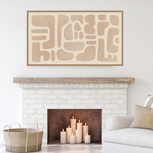 Puede incluir: Una impresi&oacute;n de arte abstracto beige con formas geom&eacute;tricas cuelga sobre una chimenea de ladrillo blanco con velas encendidas.