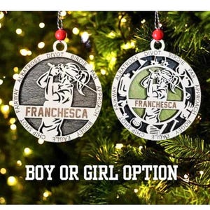 May include: Two circular golf-themed Christmas ornaments, one dark gray and one light green, feature a golfer silhouette and text including 
