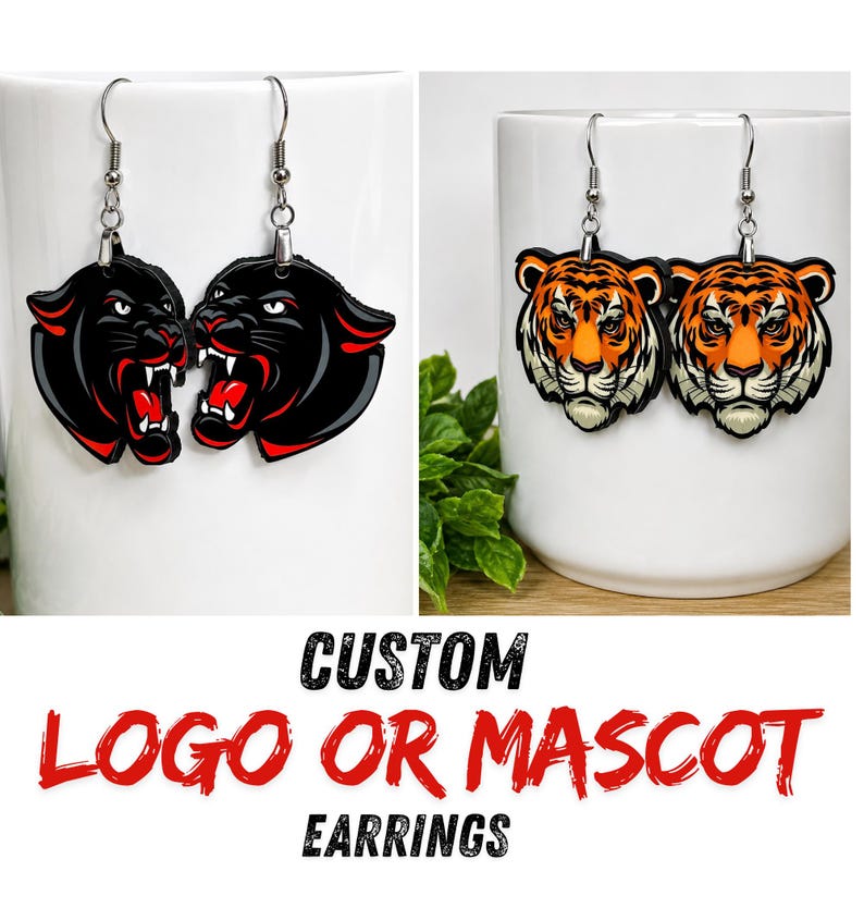 May include: Two pairs of dangling earrings featuring custom animal mascots. One pair displays black panther heads with bared teeth, while the other pair shows orange and black tiger heads. Each earring hangs from a silver-toned metal hook.