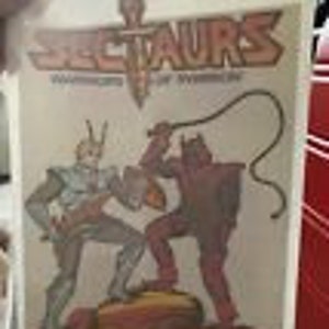 May include: A vintage comic book cover featuring the title "Spectraurs: Warriors of the World". The cover art depicts two characters in a battle scene, one with a sword and the other with a whip.