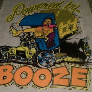 May include: A vintage illustration of a cartoon hot rod with a barrel in the back, driven by a cartoon man with a beer bottle in his hand. The text "Powered by Booze" is written in yellow and orange letters.