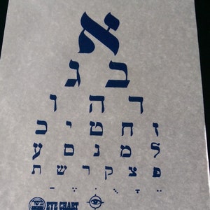 May include: An eye chart with Hebrew letters printed in blue ink on a white background. The letters are arranged in rows, starting with the largest letters at the top and getting smaller as they go down. The chart also includes a small eye symbol at the bottom.