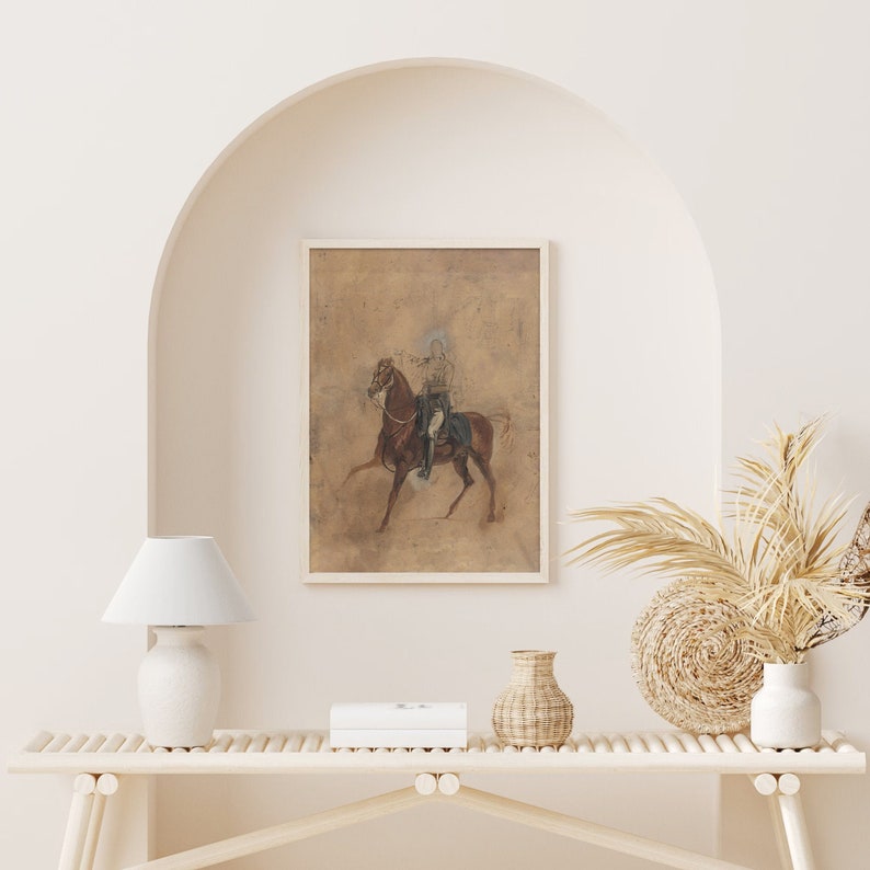 May include: A framed sepia-toned drawing of a person on horseback. The drawing is on a textured paper background and is framed in a simple white frame.