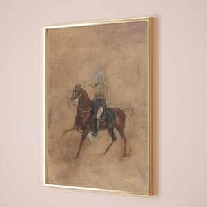 May include: A framed painting of a person on horseback. The painting is done in a muted palette of browns and grays, with the figure of the rider appearing almost ghostly.