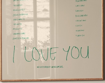 May include: A beige poster with a window reflection in the background. The poster features the phrase "I love you" written in green ink, followed by the words "in different languages".  The poster lists the phrase "I love you" in various languages, including Spanish, French, Italian, German, Mandarin, Portuguese, Arabic, Dutch, Japanese, Swedish, Romanian, Latvian, Danish, Bulgarian, Croatian, Czech, Korean, and Turkish.