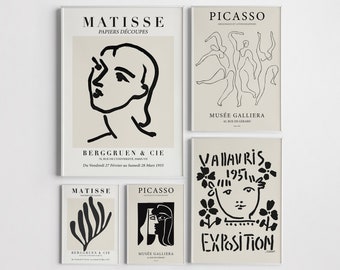 May include: A collection of framed art prints featuring minimalist line drawings and text. The prints showcase works by Matisse and Picasso, with text including "MATISSE," "PAPIERS DÉCOUPES," and "MUSÉE GALLIERA." The color palette is neutral, with black and beige tones.