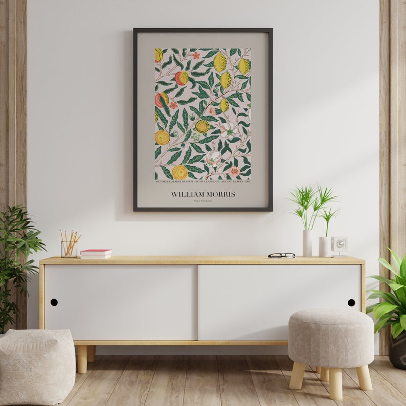May include: A framed print of a vintage botanical illustration featuring a pink background with green leaves, yellow lemons, and orange flowers. The print is titled "William Morris".