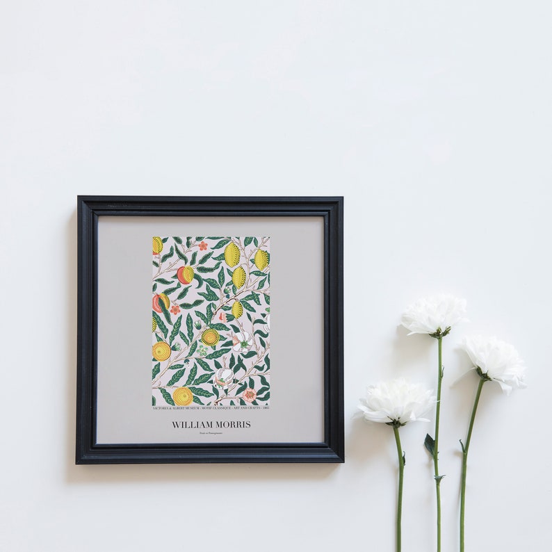May include: A black framed print of a botanical illustration featuring a lemon tree with yellow lemons, green leaves, and pink flowers. The print is titled "William Morris" and includes the text "VICTORIA & ALBERT MUSEUM, WOVEN CLOTHS AND ART FABRICS, 1883."