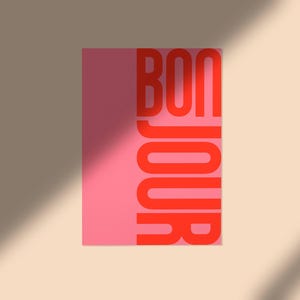 Pode incluir: Um cart&atilde;o rosa com a palavra "BONJOUR" em letras vermelhas.