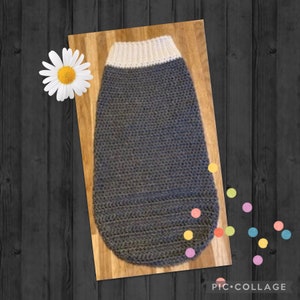 May include: A grey crocheted dog sweater with a white crocheted collar.