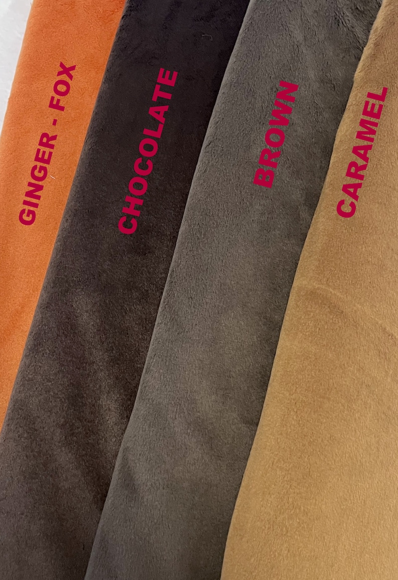 Puede incluir: Primer plano de muestras de tela en tonos naranja, marr&oacute;n y beige. Los colores est&aacute;n etiquetados con los nombres "Ginger - Fox", "Chocolate", "Brown" y "Caramel" en texto rojo. La tela parece suave y afelpada.