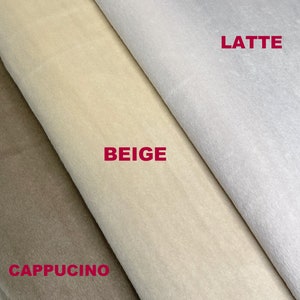 Puede incluir: Primer plano de tres muestras de tela en tonos beige, latte y capuchino. La palabra "BEIGE" est&aacute; impresa en rojo en la muestra central. La tela parece suave y afelpada, con un ligero brillo.