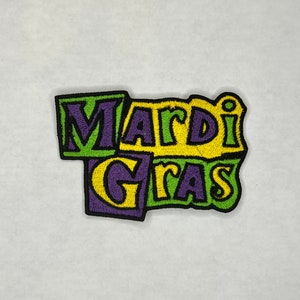 May include: A colorful embroidered patch with the words "Mardi Gras" in yellow, green, and purple.