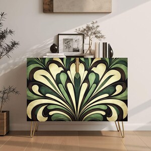May include: A cabinet with a green, cream, and brown floral design on the front. The cabinet has gold-colored legs and is topped with books, a framed picture, and decorative items. The cabinet is a stylish storage solution.