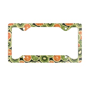 May include: A green and orange license plate frame with a pattern of kiwi and orange slices.