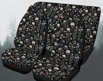 May include: Set of black car seat covers with a floral pattern featuring white, pink, and yellow flowers on a dark background.