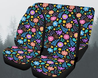 May include: Car seat covers with a floral pattern. The covers feature a black background with a colorful design of pink, blue, yellow, and purple flowers and green leaves. The seat covers are designed to fit a car seat.