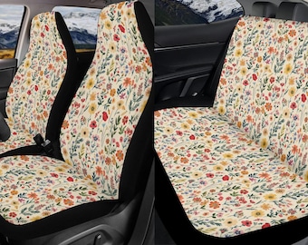 May include: A set of two car seat covers with a floral pattern. The covers are cream-colored with a variety of colorful flowers and leaves. The covers are made of a soft, comfortable fabric and are easy to install.