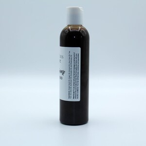 May include: A brown glass bottle with a white pump top and a white label that reads "Citrus & Hemp Shampoo".