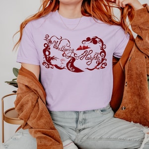 以下が含まれることがあります： 薄紫色のTシャツで、バーガンディの装飾的なフォントで「Wuthering Heights」の文字が特徴です。 デザインには、風景と人物のシルエットのイラストが含まれています。 シャツは柔らかい素材で作られています。