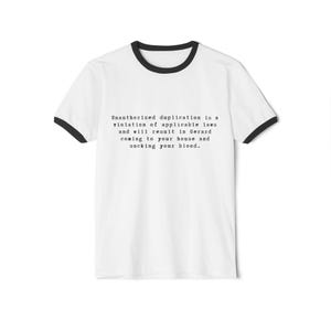 Könnte beinhalten: Weißes Ringer-T-Shirt mit schwarzem Besatz an Kragen und Ärmeln. Das Shirt zeigt einen Text in schwarzer Schrift, der lautet: "Unbefugte Vervielfältigung ist ein Verstoß gegen geltendes Recht und führt dazu, dass Gerard zu Ihnen nach Hause kommt und Ihr Blut aussaugt."