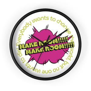Könnte beinhalten: Eine runde Wanduhr mit schwarzem Rahmen und weißem Zifferblatt. Die Uhr zeigt den Text "MAKE ROOM!!!!! MAKE ROOM!!!!!" in gelber Schrift über einer rosa Burst-Grafik. Die Uhr hat auch den Text "Everybody wants to change the world, but no one wants to die" in gelber Schrift.