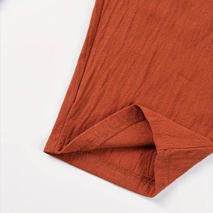 a close up of a red shirt on a white surface