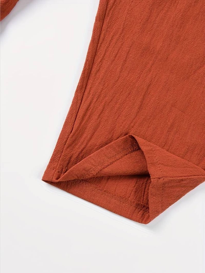 a close up of a red shirt on a white surface