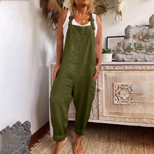 a woman standing in a room wearing a green jumpsuit