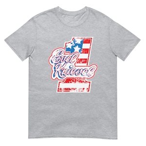 May include: Gray t-shirt with a distressed, red, white, and blue graphic of the number "1" with the text "Evel Knievel" in a vintage style.
