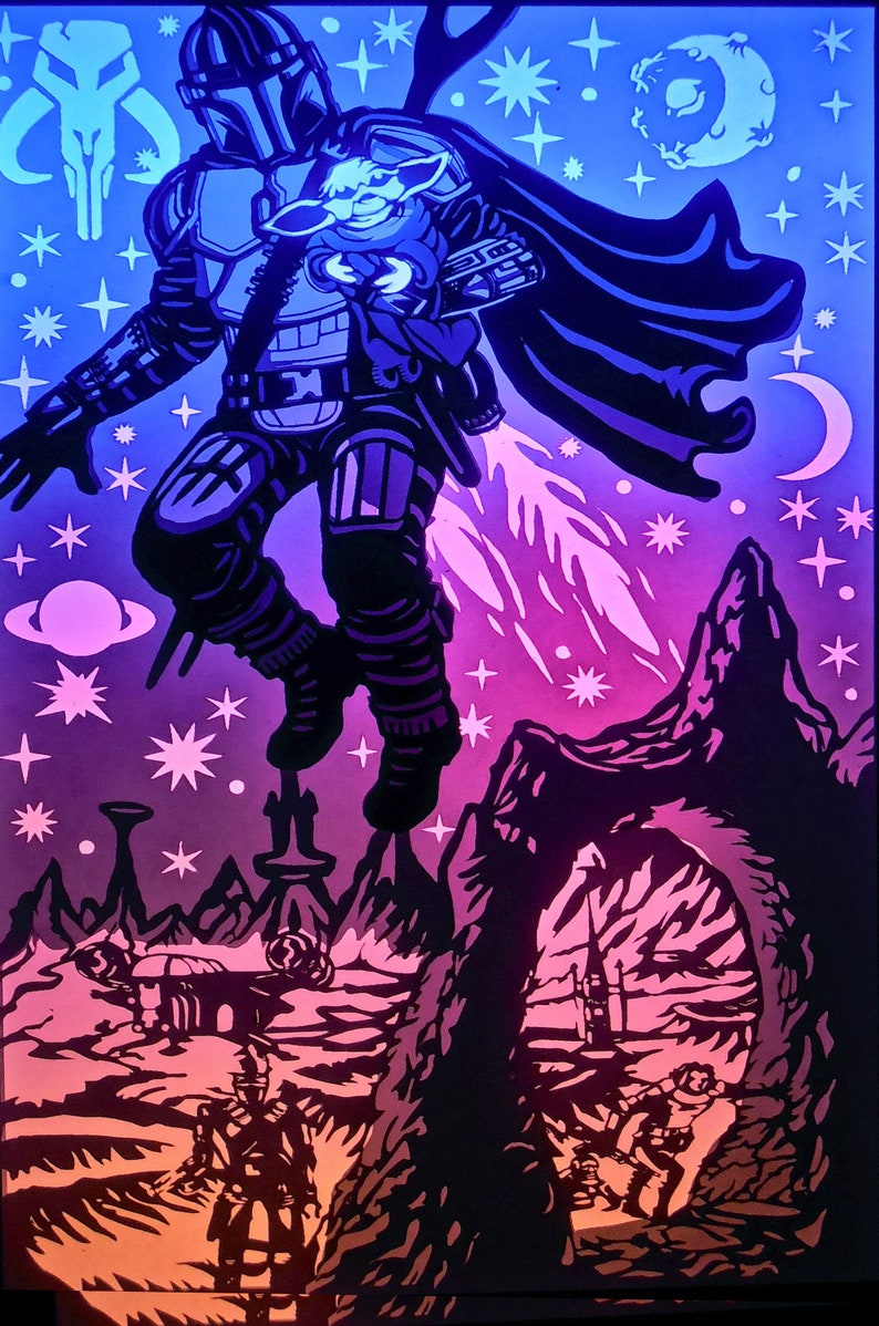 May include: A layered paper art piece depicting a figure in Mandalorian armor with a child, set against a space-themed background. The artwork uses shades of blue, purple, and orange, with stars, planets, and a crescent moon. The Mandalorian is shown mid-flight with jet propulsion.