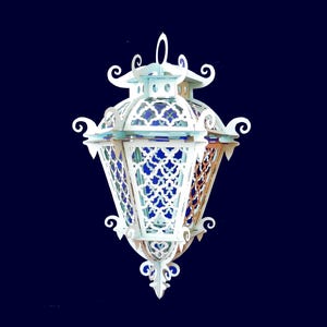 May include: White decorative lantern with intricate cut-out designs. The lantern has a traditional Moroccan style with a geometric pattern.