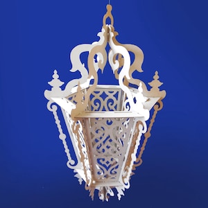 May include: A white wooden decorative lantern with intricate cutouts and a hexagonal base. The lantern has a chain hanging from the top and a decorative finial.
