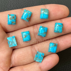 May include: Nine turquoise cabochons with a brown matrix. The cabochons are rectangular and have a smooth, polished surface.