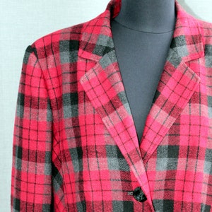 May include: A red and black checked blazer with a single button fastening. The blazer has a notched collar and a classic fit.