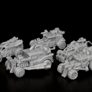 Può includere: Cinque auto in miniatura di plastica grigia, dettagliate, con diversi design e armi. Le auto sono su una superficie nera.