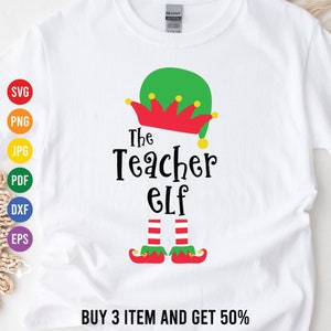 May include: White t-shirt with a green elf hat, red and yellow trim, and the text "The Teacher Elf" in black. The elf has red and white striped legs and green shoes with yellow buckles.