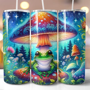 May include: A stainless steel tumbler featuring a colourful illustration of a frog sitting beneath a mushroom in a woodland scene. The mushroom has a red and orange cap with blue and purple swirls. The frog is green with a white belly and black eyes. The background is a blue and green woodland with stars and flowers.