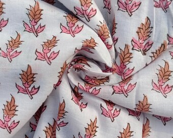 May include: White cotton fabric with a repeating pattern of brown and pink stylized floral sprigs.