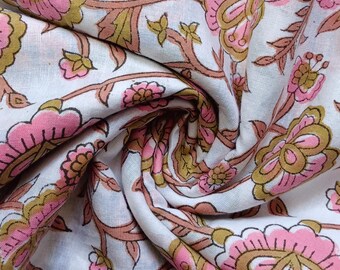 May include: White fabric with a pink and brown floral print. The fabric is folded and shows the pattern.